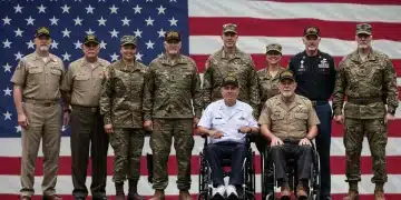 Diverse group of veterans standing with American flag, representing community and support.